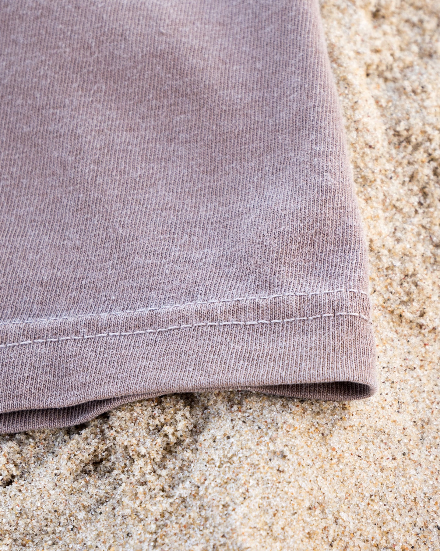 Close-up of a folded purple fabric on sand