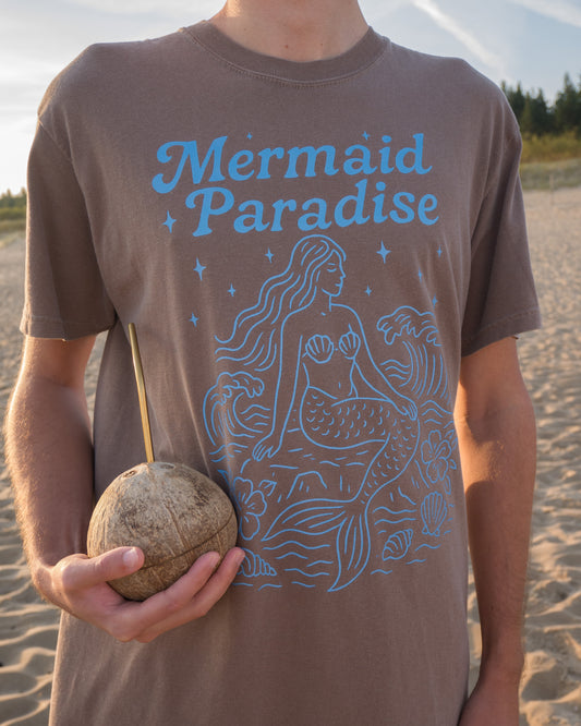 Person wearing a 'Mermaid Paradise' t-shirt on a beach