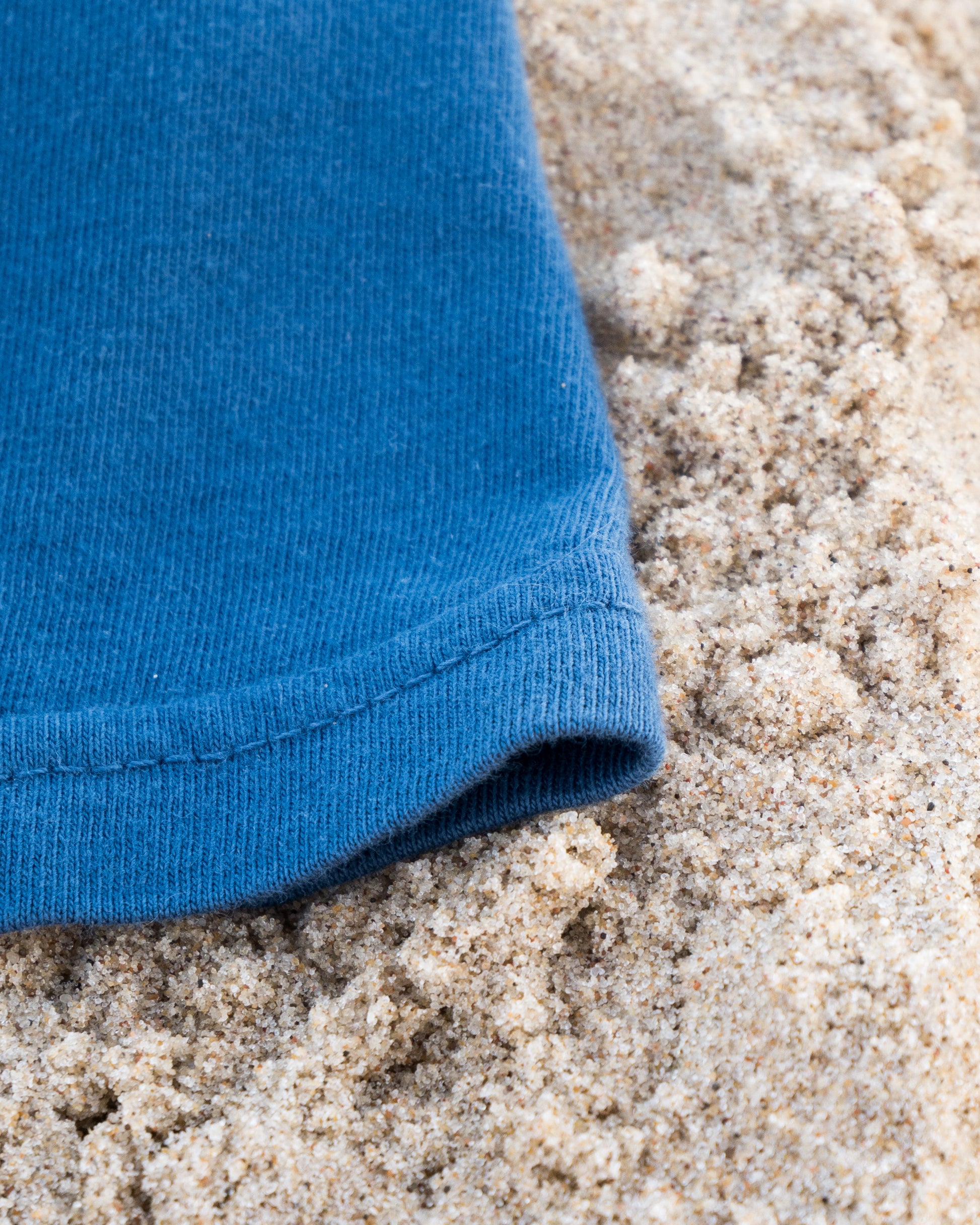 Blue fabric on a sandy surface