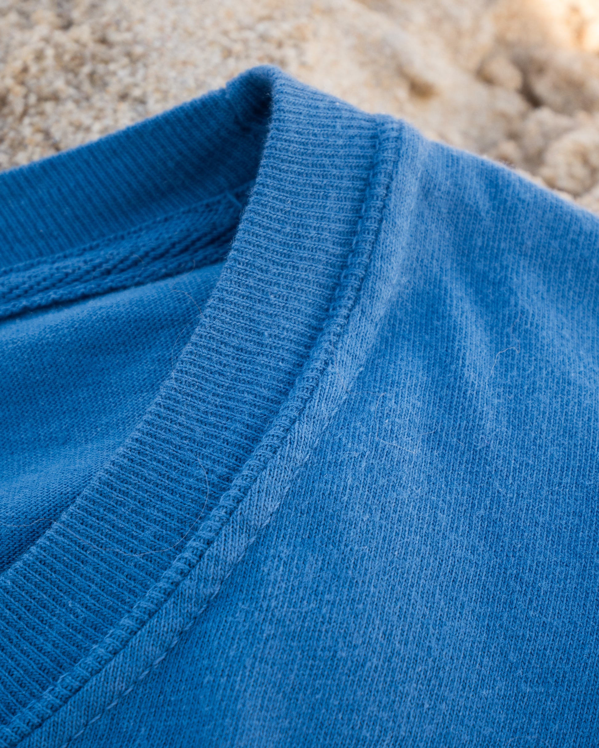 Close-up of a blue fabric texture with a blurred natural background