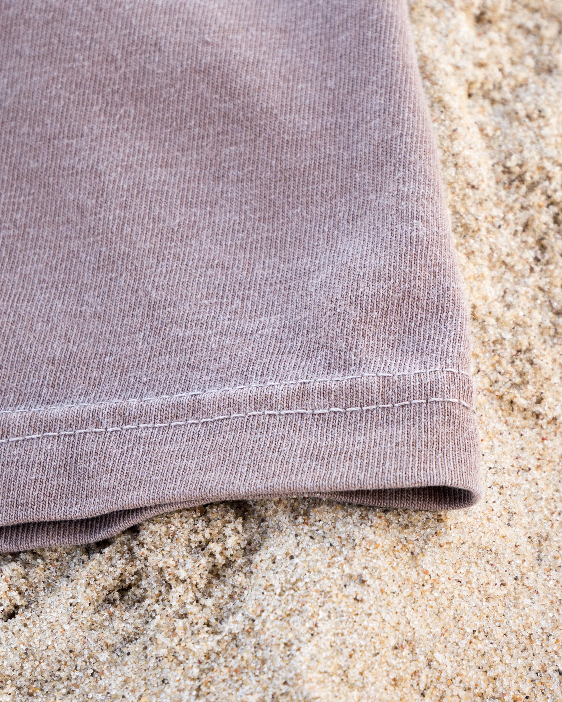 Close-up of a folded purple fabric on sand