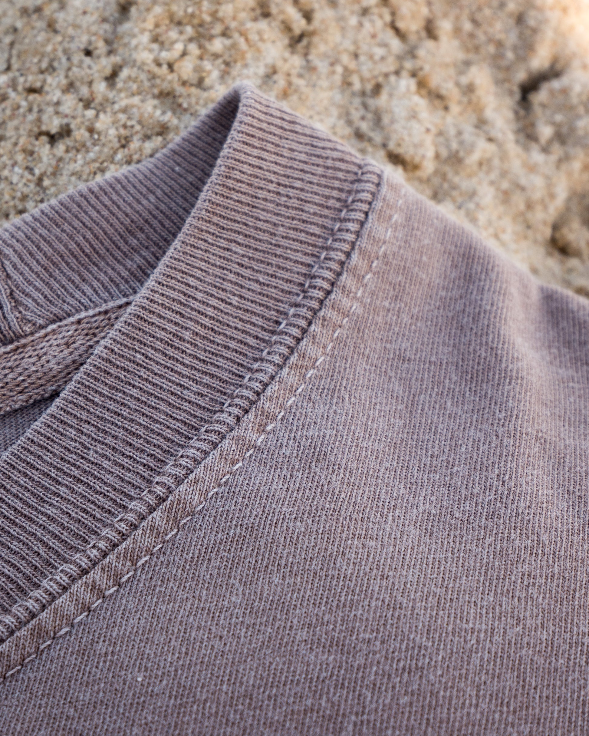 Close-up of a gray fabric collar with sand in the background